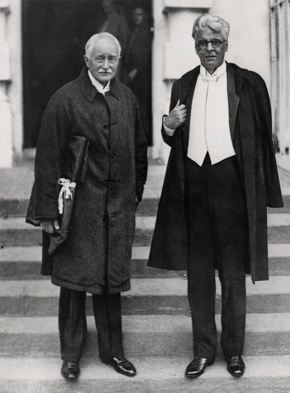 A black and white photograph of John Masefield and WB Yeats, two middle-aged white men wearing formal attire. 