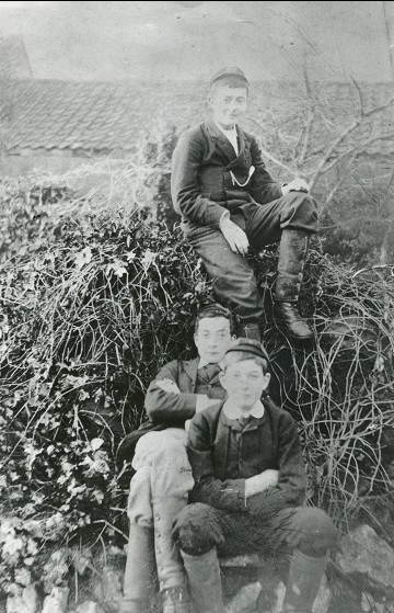 A black and white photograph of three boys in the Victorian era. 